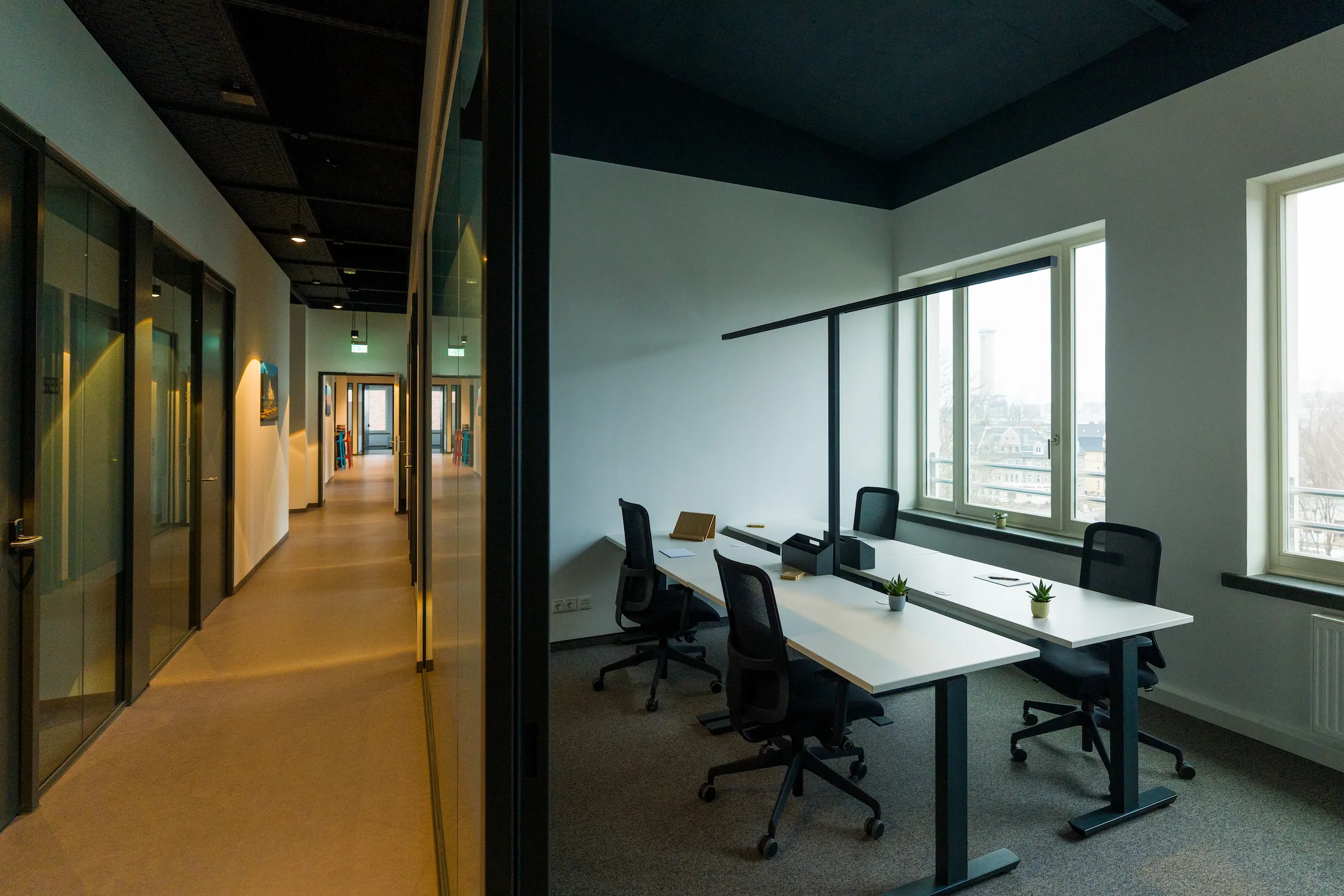 Teambüro mit Arbeitsplätzen und verglaster Flur